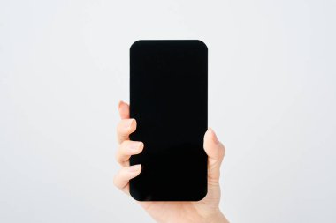 Akıllı telefon ve beyaz arka plan taşıyan bir kadının eli