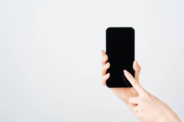 Akıllı telefon ve beyaz arka plan taşıyan bir kadının eli
