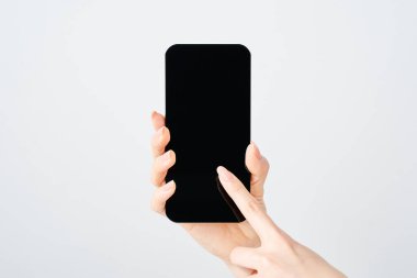 Akıllı telefon ve beyaz arka plan taşıyan bir kadının eli