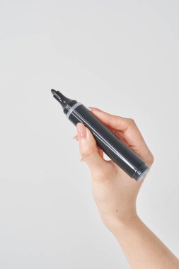 Kara büyü kalemini tutan bir kadın ve beyaz arka plan