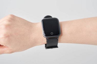 Bir kadının bileğindeki akıllı saat ve beyaz arka plan.