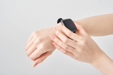 Bir kadının bileğindeki akıllı saat ve beyaz arka plan.