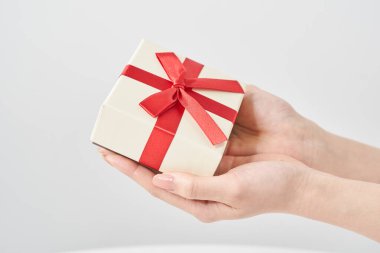 Bir kadının eli hediye olarak bir kutuyu tutar.