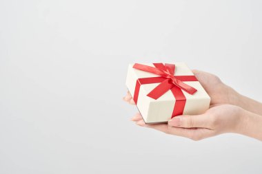 Bir kadının eli hediye olarak bir kutuyu tutar.