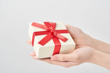 Bir kadının eli hediye olarak bir kutuyu tutar.