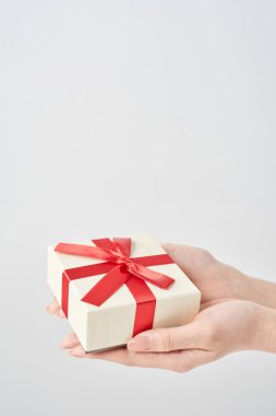 Bir kadının eli hediye olarak bir kutuyu tutar.