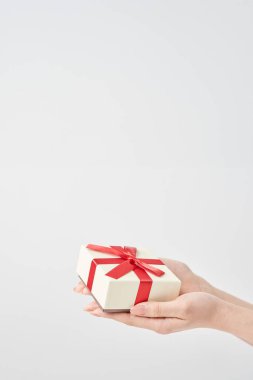 Bir kadının eli hediye olarak bir kutuyu tutar.