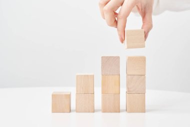 Tahta blokları ve beyaz arka planı olan bir kadının elleri.