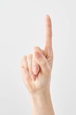 Bir kadının işaret parmağı yukarı ve beyaz arkaplanı işaret ediyor