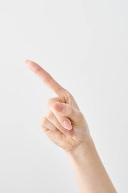 Bir kadının işaret parmağı çapraz olarak yukarı ve beyaz arkaplanı gösteriyor