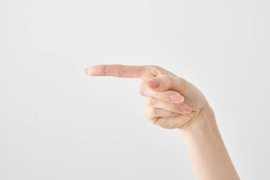 Kadın işaret parmağı yan ve beyaz arkaplanı gösteriyor