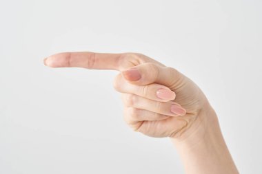 Kadın işaret parmağı yan ve beyaz arkaplanı gösteriyor