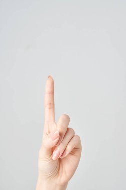 Bir kadının işaret parmağı yukarı ve beyaz arkaplanı işaret ediyor