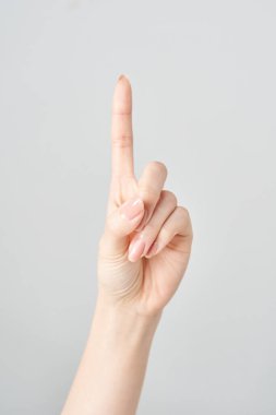 Bir kadının işaret parmağı yukarı ve beyaz arkaplanı işaret ediyor