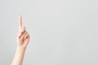 Bir kadının işaret parmağı yukarı ve beyaz arkaplanı işaret ediyor