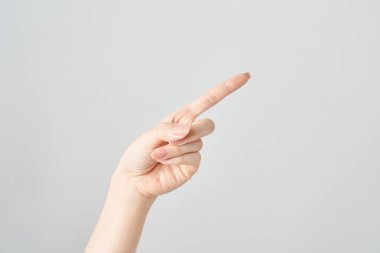 Bir kadının işaret parmağı çapraz olarak yukarı ve beyaz arkaplanı gösteriyor