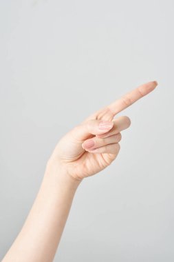Bir kadının işaret parmağı çapraz olarak yukarı ve beyaz arkaplanı gösteriyor