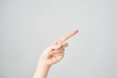 Bir kadının işaret parmağı çapraz olarak yukarı ve beyaz arkaplanı gösteriyor