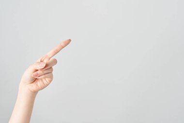 Bir kadının işaret parmağı çapraz olarak yukarı ve beyaz arkaplanı gösteriyor