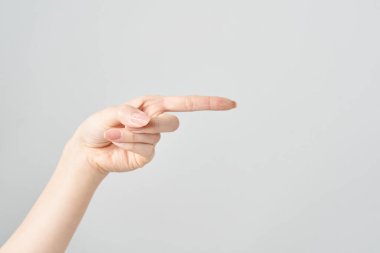 Kadın işaret parmağı yan ve beyaz arkaplanı gösteriyor
