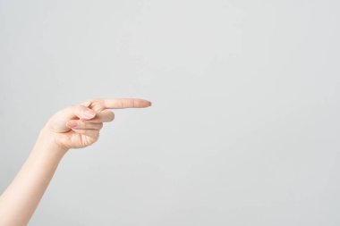 Kadın işaret parmağı yan ve beyaz arkaplanı gösteriyor