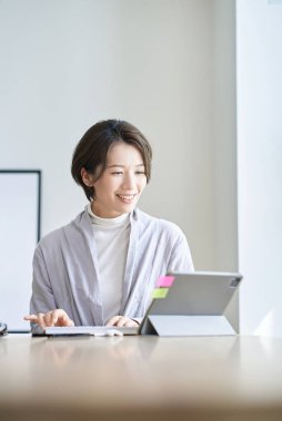 Orta yaşlı bir kadın bir odada çalışıyor.