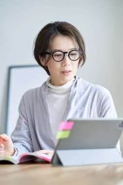 Orta yaşlı bir kadın bir odada çalışıyor.