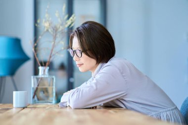 Orta yaşlı bir kadın odasında mola veriyor.