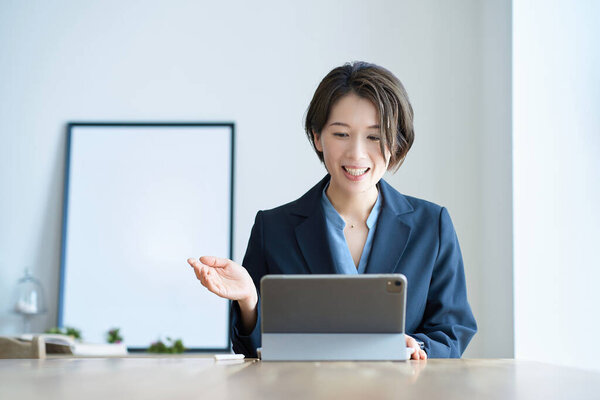 Middle-age woman in a suit during an online meeting