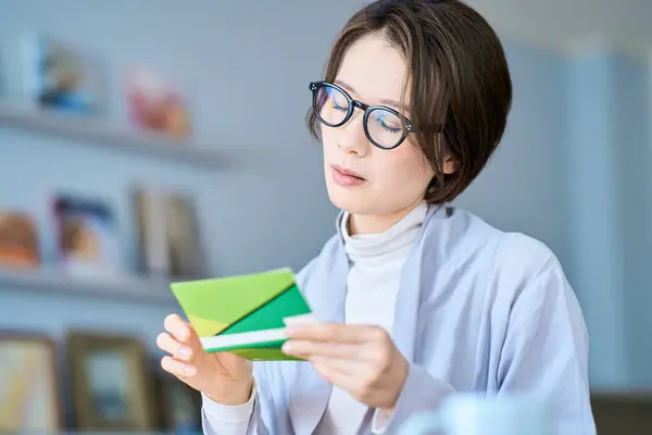 stock image A woman looking at her bank account passbook with a troubled expressio
