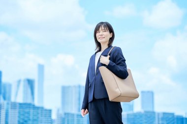 Takım elbiseli genç bir kadın güzel bir günde işe gidip geliyor.