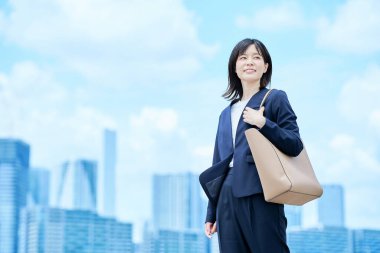 Takım elbiseli genç bir kadın güzel bir günde işe gidip geliyor.