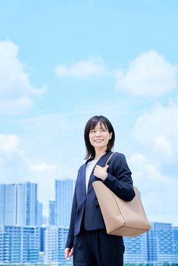 Takım elbiseli genç bir kadın güzel bir günde işe gidip geliyor.