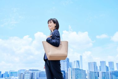 Takım elbiseli genç bir kadın güzel bir günde işe gidip geliyor.