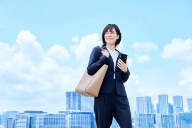 Takım elbiseli genç bir kadın güzel bir günde işe gidip geliyor.