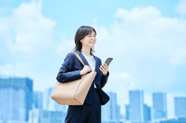 Takım elbiseli genç bir kadın güzel bir günde işe gidip geliyor.