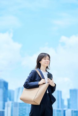 Takım elbiseli genç bir kadın güzel bir günde işe gidip geliyor.