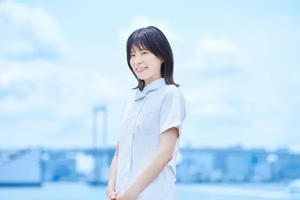 stock image Young woman wearing a white coat outdoors