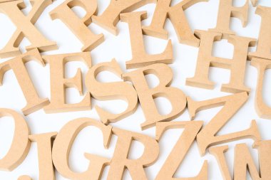 Ahşap alfabe blokları karışık ve beyaz bir arkaplanda sıralanmış