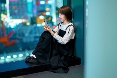 Akıllı telefon kullanan genç bir kadın.