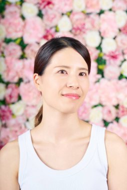 Kolsuz bluz ve beyaz arka plan giyen bir kadın.