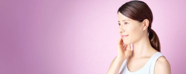 A woman checking her skin condition with a pink background clipart