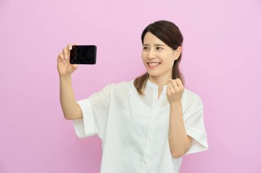 İçerideki akıllı telefon ekranına bakan genç kadın.