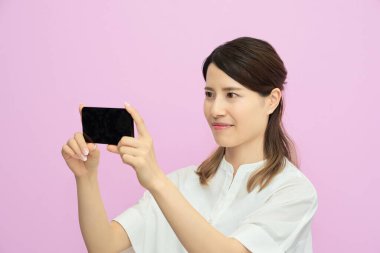 İçerideki akıllı telefon ekranına bakan genç kadın.