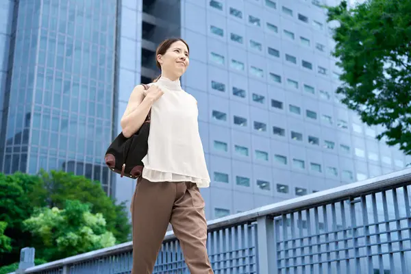 İş bölgesinde günlük kıyafetleriyle gezen bir kadın.