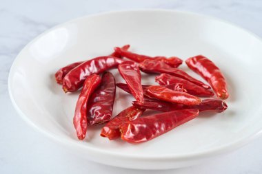 Tabaktaki acı biberleri yakın.