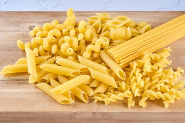 Tahtadaki farklı makarna türlerinin grup fotoğrafı.