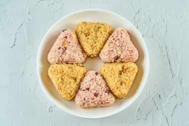 Beyaz bir tabakta iki çeşit pirinç topu.