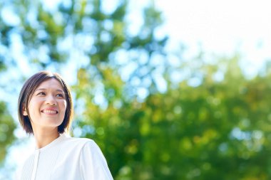 Güneşli bir günde yeşillikte dinlenen bir kadın.
