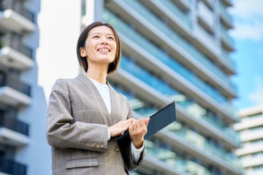 İş kadını güzel bir günde apartmanın önünde duruyor.